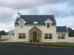 a large white house with a black roof at No 4 Ballymastoker Cottage in Portsalon