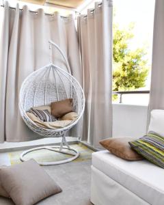 a white hanging chair in front of a window at Angelos Boutique Suites in Patitiri