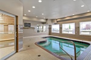 a large swimming pool in a bathroom with a swimming poolvisor at Canalta Hotel Weyburn in Weyburn