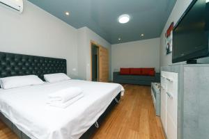 a bedroom with a large bed and a flat screen tv at Шикарная 1 комнатная квартира на Русовой 7 in Kyiv