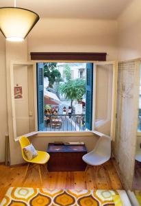 ein Wohnzimmer mit 2 gelben Stühlen und einem Fenster in der Unterkunft Artistic Getaway Home - Super Central in Iraklio