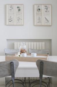 een eettafel met twee stoelen en twee foto's aan de muur bij Casa Chiara in Porto Recanati