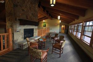 a room with a fireplace and chairs and a table at YMCA of the Rockies in Estes Park