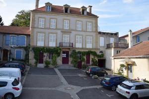 a large building with cars parked in a parking lot at L'orée du Saint Quentin in Lessy