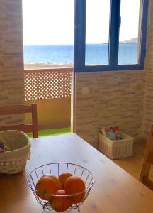 Apartamento Playa Ciudad في سانتا كروث دي لا بالما: وعاء من البرتقال على طاولة مطلة على المحيط