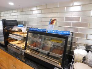 a bakery counter with many trays of food at Best Western Plus - Anaheim Orange County Hotel in Placentia