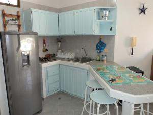 a kitchen with blue cabinets and a sink and a refrigerator at Edificio Mar de Leva in Santa Marta