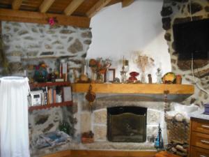 - un salon avec une cheminée en pierre et une télévision dans l'établissement Casa do Beirado, à Gouveia