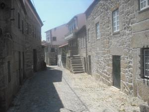 an alley in an old town with stone buildings at Casa do Beirado in Gouveia