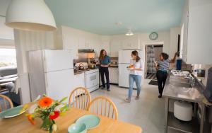 a group of women standing in a kitchen at HI Pigeon Point Lighthouse Hostel in Pescadero