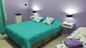 Un dormitorio con una cama y dos mesitas de noche con lámparas. en Complejo EL ANGEL, en Río Colorado