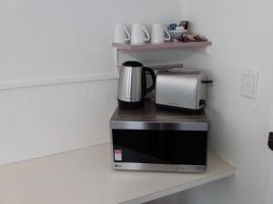 a microwave sitting on a counter with a coffee maker on it at Green Door Motel in Albury