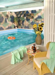 a swimming pool with a table and a vase of flowers at Hotel am See in Neubäu