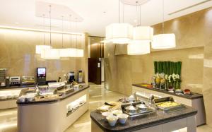 ein Buffet in einer Hotelküche mit Kronleuchtern in der Unterkunft Holiday Inn Express Shanghai Jinsha by IHG in Shanghai