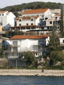 a group of houses on a hill next to the water at Guest House Babić in Neum