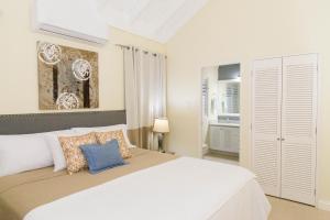 a bedroom with a large white bed with pillows at Coolshade Villa Mahoe II Ocho Rios in Ocho Rios +29 photos