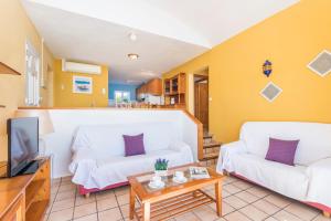 sala de estar con 2 sofás blancos y TV en Villa Elena - Son Bou, en Son Bou