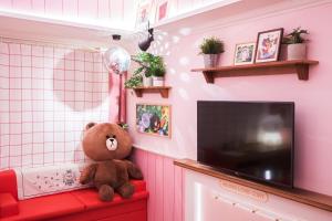a teddy bear sitting on a red couch in a room at Sotetsu Hotels The Splaisir Seoul Myeongdong in Seoul