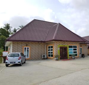 a house with a car parked in front of it at Pilly Homestay in Labuan