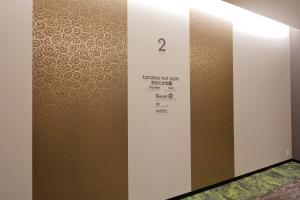 a room with a wall with a door with a pattern at karaksa hotel Sapporo in Sapporo
