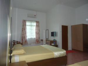 een slaapkamer met een bed en een raam bij VillaSetia in Kampong Gong Badak