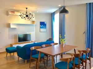 a dining room with blue chairs and a table at Angela House Halong in Ha Long