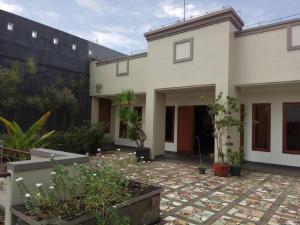 une maison blanche avec une cour ornée de plantes dans l'établissement GK Gallery Rumah Sewa, à Purwokerto
