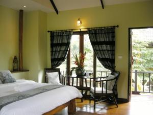 a bedroom with a bed and a table and chairs at Baan Thai House in Phra Nakhon Si Ayutthaya