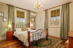 a bedroom with a bed and two windows at Crabtree House in Huonville