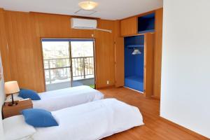 a hotel room with two beds and a window at Grand Bleu in Katase