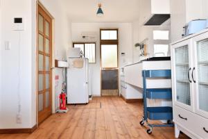 a kitchen with a refrigerator and a hard wood floor at Grand Bleu in Katase