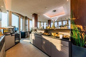 a large kitchen with a counter with food on it at aquaTurm Hotel & Energie in Radolfzell am Bodensee
