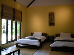 a bedroom with two beds and a window at Baan Thai House in Phra Nakhon Si Ayutthaya