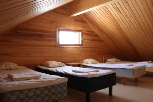 a room with three beds in a wooden cabin at Youth Center Vasatokka in Inari
