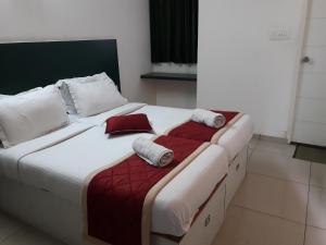 a bedroom with a large bed with towels on it at SAP Golden Grande Electronic City in Bengaluru +27 photos