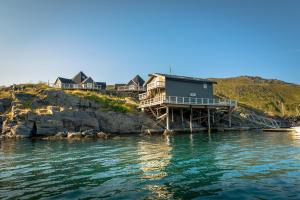 a house on the edge of a body of water at Cape Marina Lodge in Skarsvåg