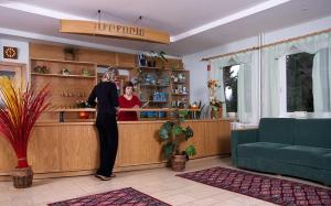 a woman standing at the counter of a bar at Bungalovy pri Hoteli Spojar in Žiar