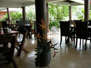 a restaurant with tables and chairs and a potted plant at Baan Thai House in Phra Nakhon Si Ayutthaya