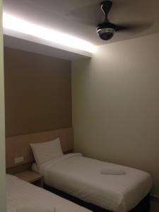 a room with two beds and a ceiling fan at Festival Boutique Hotel @ Kampung Pandan in Kuala Lumpur