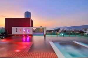 a pool on the roof of a building at night at SLEEP WITH ME HOTEL design hotel @ patong (SHA Plus+) in Patong Beach