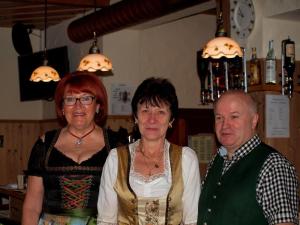 two women and a man standing in a bar at Zum Schiffmeister in Wesenufer