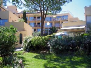 a large apartment building with a garden in front of it at Les Residences Pinea in Calvi