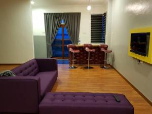 a living room with a couch and a table and stools at Andalus beach residence in Marang