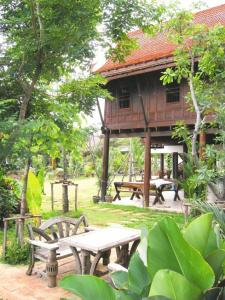 a picnic table and benches in front of a building at Baan Thai House in Phra Nakhon Si Ayutthaya