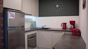 a kitchen with a refrigerator and a counter top at Apartament Piano 3 in Racibórz