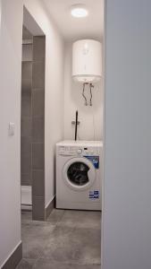 a laundry room with a washing machine and a lamp at Apartament Piano 3 in Racibórz