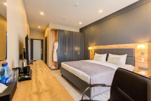 a hotel room with a large bed and a dresser at Aurum hotel in Bishkek