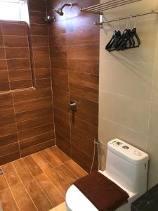 a bathroom with a toilet and a shower with wooden tiles at Festival Boutique Hotel - Damai Complex in Kuala Lumpur