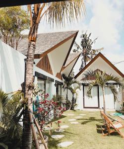 a house with a palm tree in front of it at Beyond Bungalows in Canggu