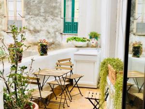 un balcón con mesas, sillas y plantas en I Lumi, en Catania